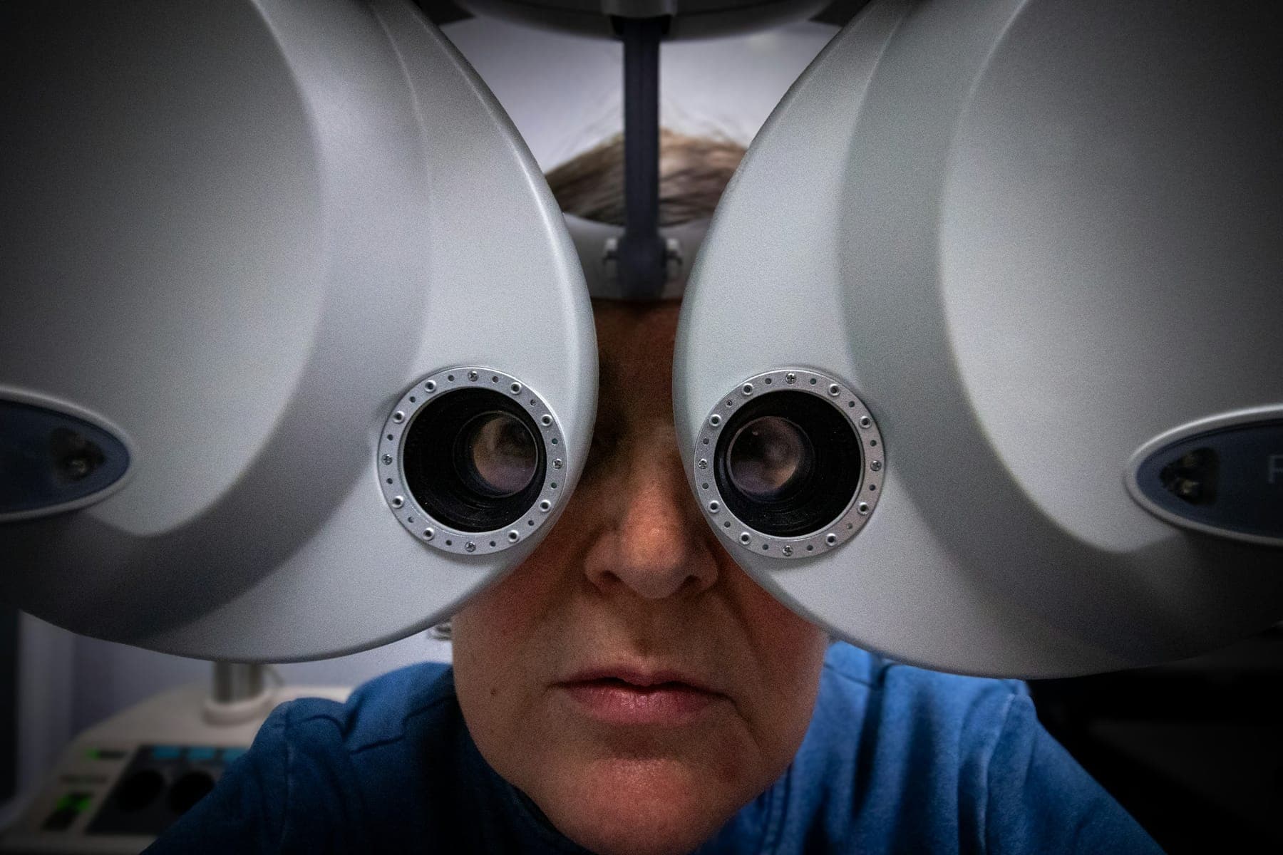 Patient looking through a phoropter during measurement