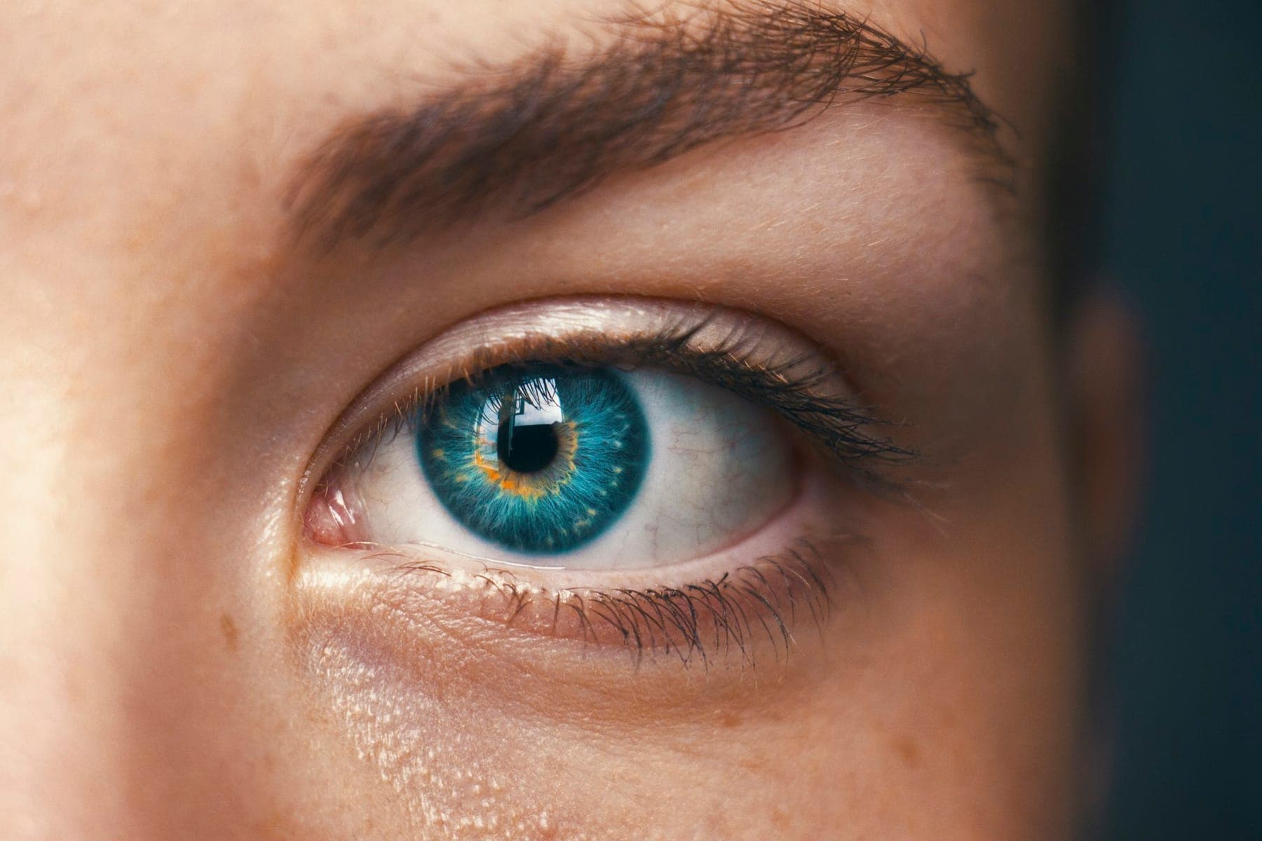 Close-up of a teal-blue eye with natural lashes