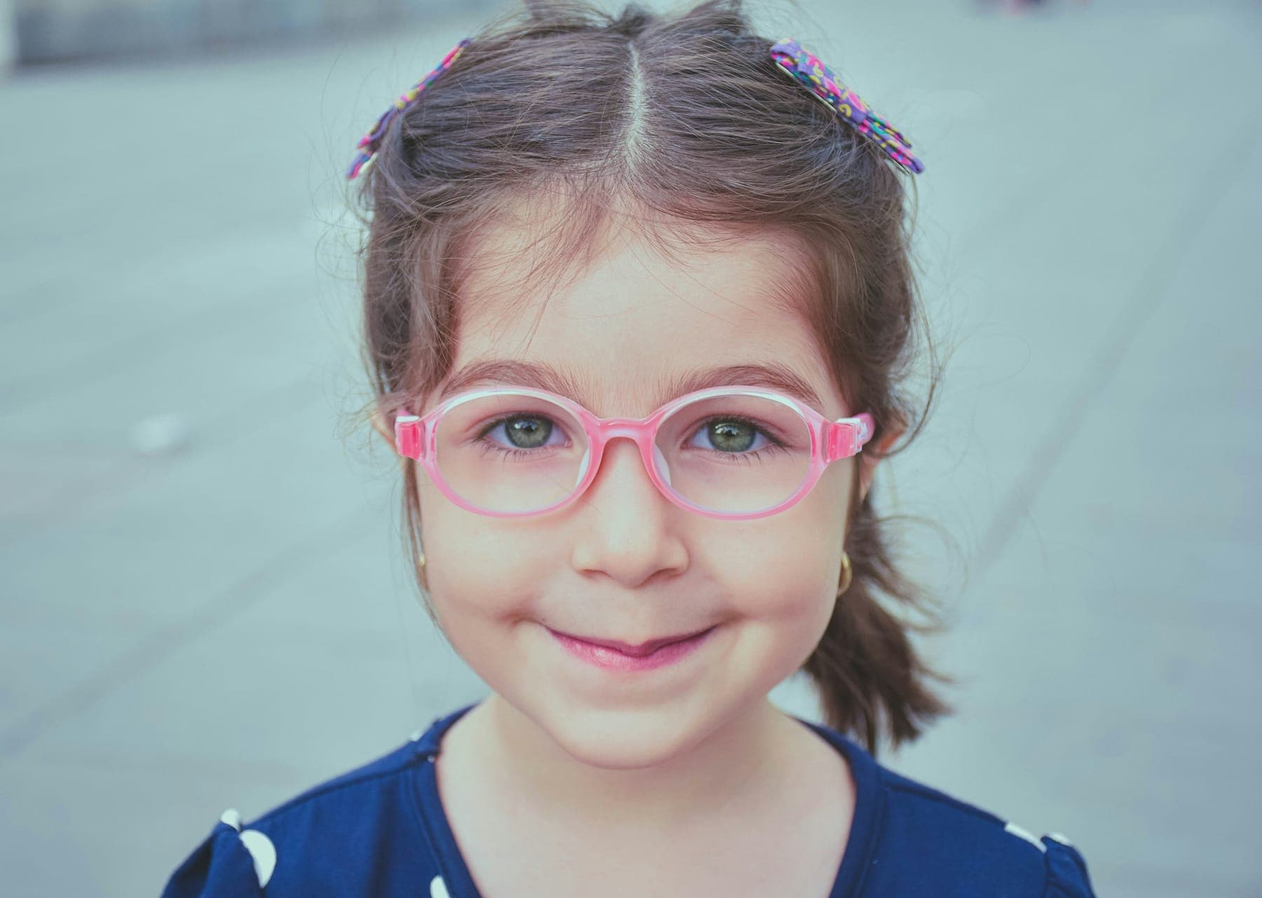 Smiling young girl wearing pink-framed glasses