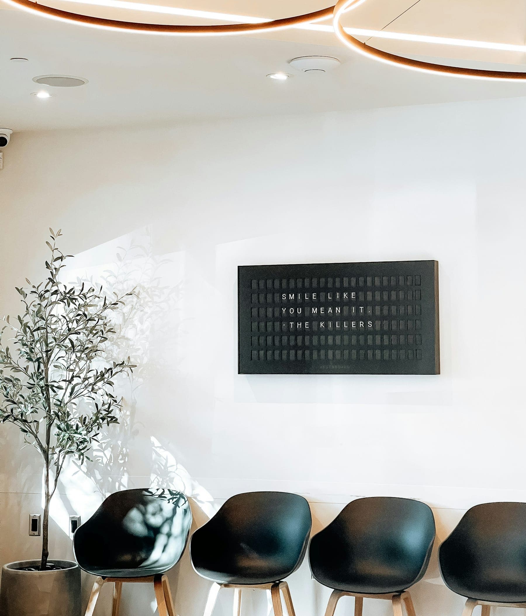 Bright, minimal waiting area with black chairs